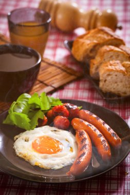 Fried egg for breakfast with sausage and bread