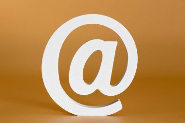 Kahraman @, modern iletişimin sembolü, nötr bir arkaplan üzerindeki dijital dünyadır..