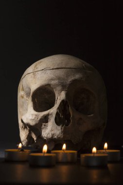 Kafatasının önünde beş mum, etrafındaki her şey karanlık, cadılar bayramı.