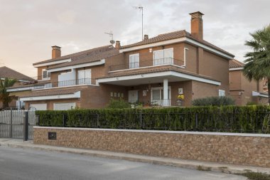 View of a villa from the street in a residential area in Sagunto, Spain, at dusk. Contemporary architecture building, early 21st century clipart