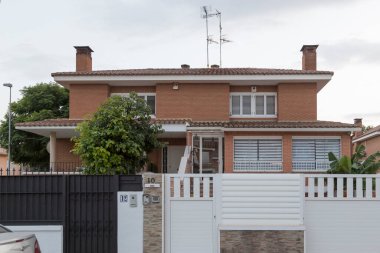 Chalet, view from the street, in a residential area in Sagunto, Spain, at dusk. Buildings of contemporary architecture. clipart