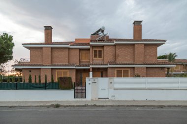 Yarı müstakil bir ev, iki apartman dairesi, gün batımında İspanya 'nın Sagunto kentindeki bir yerleşim bölgesinde sokaktan manzara. Çağdaş mimari binalar.