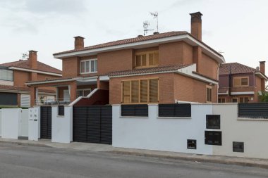 Yarı müstakil bir ev, iki apartman dairesi, gün batımında İspanya 'nın Sagunto kentindeki bir yerleşim bölgesinde sokaktan manzara. Çağdaş mimari binalar.