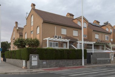 Yarı müstakil evlerin kentleşmesi; alacakaranlıkta İspanya 'nın Sagunto kentindeki sokaktan manzara. Çağdaş mimari binaları.