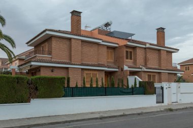 Yarı müstakil bir ev, iki apartman dairesi, gün batımında İspanya 'nın Sagunto kentindeki bir yerleşim bölgesinde sokaktan manzara. Çağdaş mimari binalar.