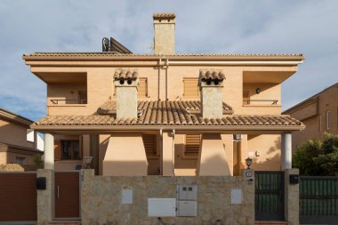 Caddenin bir tarafından, karşıdan manzara, görkemli bir ev, klasik tarzda bir dağ evi, iki konut, tuğla ön cephe ve modern yapı, Sagunto, Valencia, İspanya