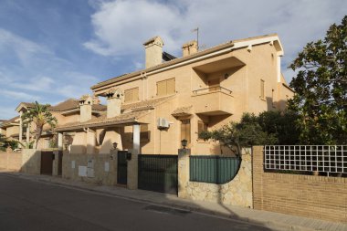 Caddenin bir tarafından, karşıdan manzara, klasik stili olan görkemli köşk tarzı evler, tuğla cephesi ve modern yapı, Sagunto, Valencia, İspanya
