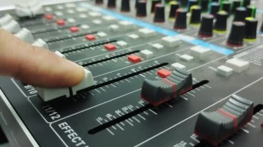  Finger to slide the volume up and down on the audio mixer.