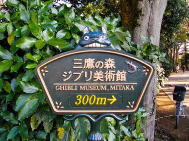Mitaka 'daki Ghibli Müzesi' ne giden yol, yeşil yapraklarla çevrili. Tuhaf karakter davetkar yola sihirli bir dokunuş ekler..