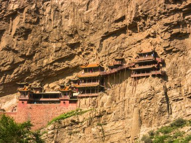 Yüksek kaya oluşumlarına karşı, etkileyici kayalık tapınaklar karmaşık tasarımlar ve canlı renkler sergiliyor, tarihin ve doğanın güzelliklerine dalmış ziyaretçileri cezbediyor. Xuankongsi, Datong, Çin.