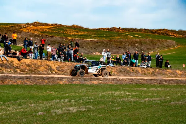 Ben MaverickCrowds bir off-road aracının manzaralı kırsal kesimde düzenlenen bir motor sporu etkinliğinde etkileyici atlayışlar ve manevralar yapmasını izlemek için toprak bir pistte toplanabilir miyim?.