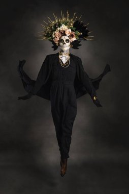 Drag Queen Catrin 'in stüdyo portresi. Çiçek tacıyla siyah giyinmiş Catrin. Cadılar bayramı ya da ölüler günü için makyaj.