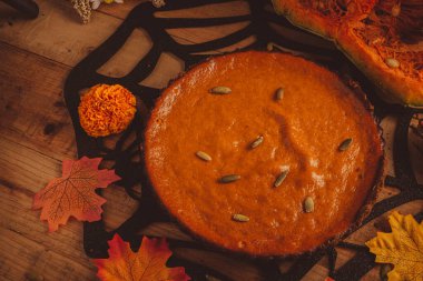 Cadılar Bayramı süsüsüyle ahşap masada balkabağı turtası. Şükran Günü yemeği için tatlı..