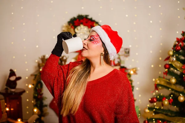 白いカップからクリスマスファンタジーメイクを飲む若い女性 クリスマスの背景 — ストック写真