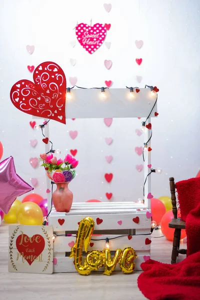 Kissing booth in photo studio for children\'s photo shoot. Photo studio decorated with balloons and hearts.
