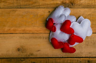 Group of hearts made of felt on wooden table. Valentine's day background.