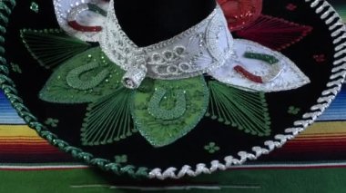 Mariachi hat with colors of the Mexican flag spinning on colorful serape. Close up