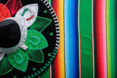 Mariachi hat with the colors of the Mexican flag on a colorful serape. Mexican sombrero.