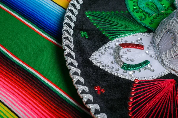 Mariachi hat with the colors of the Mexican flag on a colorful serape. Mexican sombrero.
