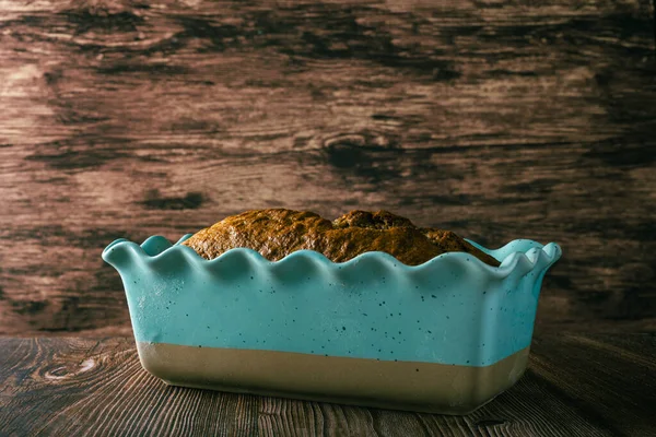 Pound cake in blue mold on wooden table. Homemade banana pound cake.