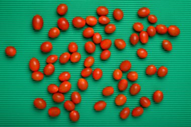 Group of cherry tomatoes separated on green background.