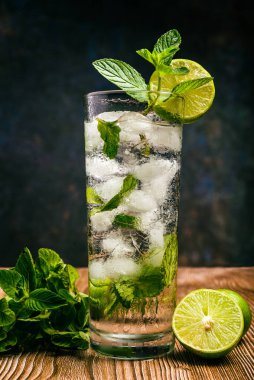 Mojito, ahşap bir masada limon ve nane şekeriyle süslenmiş kokteyl. Saman yok..
