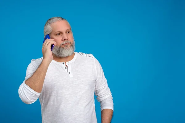 Homem Cabelo Grisalho Barba Falar Telefone Fundo Azul — Fotografia de Stock