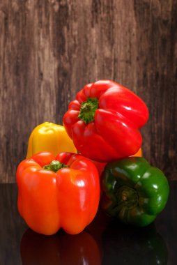 Group of peppers of different colors on a wooden table. Bell peppers of different colors.
