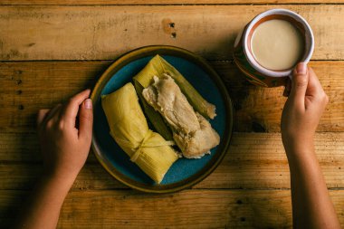 Tamales de elote ve atole tahta bir masada. Tipik Meksika yemekleri..