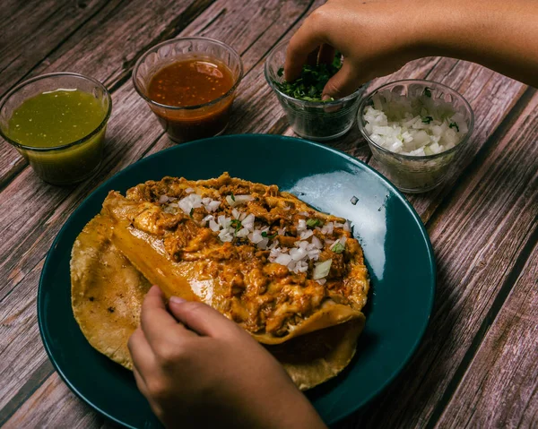 木製のテーブルの上にソースやその他の条件を伴うグリンガ牧師ラ ディアブラを準備する人の手 メキシコ料理の代表格であるグリンガ — ストック写真