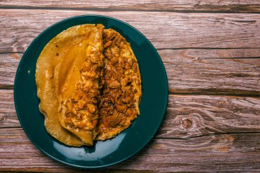 Gringa, tipik bir Meksika yemeği. Gringa papazı a la diabla ahşap bir masada soslar ve diğer baharatlarla servis edilir..