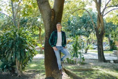 Gri saçlı bir adamın bahçede vakit geçirmesinin sıradan bir portresi..