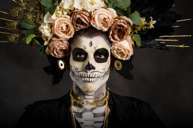 Drag Queen Catrin 'in stüdyo portresi. Çiçek tacıyla siyah giyinmiş Catrin. Cadılar bayramı ya da ölüler günü için makyaj.
