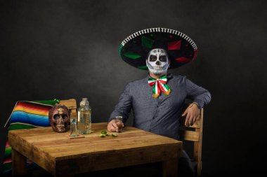 Catrin mariachi şapkası takıyor ve bir barda kadeh kaldırıyor. Ölüm bayramı..