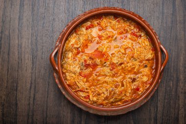 Otantik Meksika tavuğu tinga, tipik bir Meksika yemeği. Tahta masadaki kil çömlekte hazırlanır..