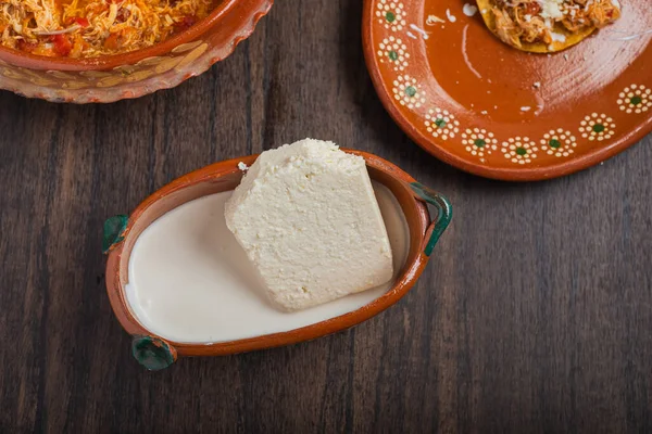 木桌上的黏土锅里有新鲜的奶酪 — 图库照片