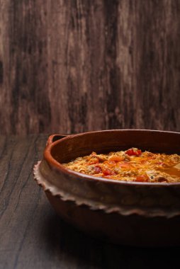 Otantik Meksika tavuğu tinga, tipik bir Meksika yemeği. Tahta masadaki kil çömlekte hazırlanır..