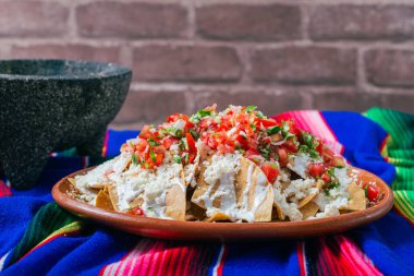 Krem peynirli nachos ve renkli bir serapede pico de gallo..