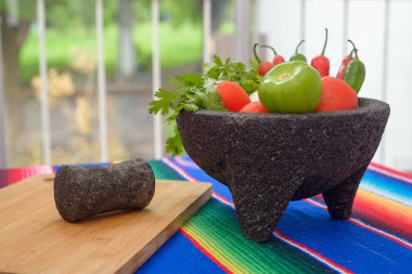 Renkli bir serapta sebzeli Molcajete. Acı sos için gerekli malzemeler.