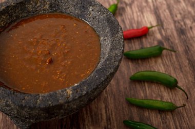 Ahşap masada acı soslu ve biberli Molcajete..