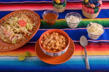 Kırmızı pozole renkli bir tabakta servis ediliyor. Tipik Meksika yemekleri mısırdan yapılır.