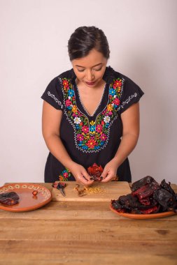 Kadın tohumları çıkarmak için acı biber açıyor. Ançüez; Meksika mutfağı çeşnisi.