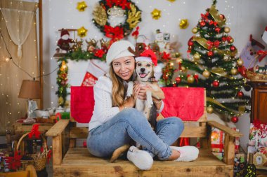 Bir kadın Noel 'i kutlayan evcil hayvanına sarılıyor.