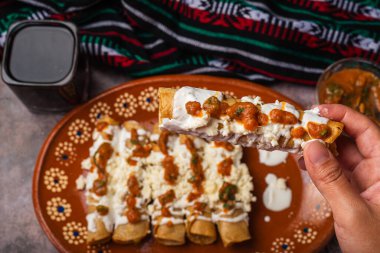 Kadının eli, yemek için altın bir taco tutuyor. Meksika yemeği.