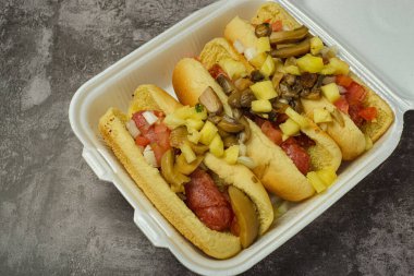 Tek kullanımlık plastik tabakta ananaslı ve mantarlı sosisli sandviç. Sokak yemeği..