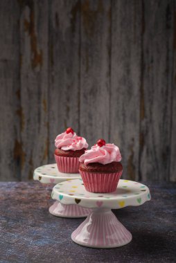 Küçük seramik tabakta keklerin altında tahta tabaka ve fotokopi alanı var. Ürün fotoğrafı..