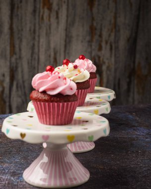 Küçük seramik tabakta keklerin altında tahta tabaka ve fotokopi alanı var. Ürün fotoğrafı..