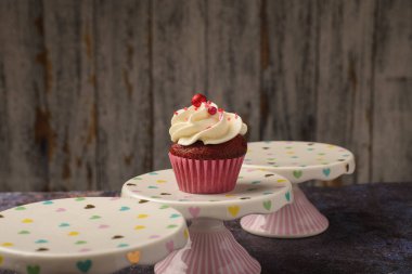 Küçük seramik tabakta kekin altında tahta tabaka ve fotokopi alanı var. Ürün fotoğrafı..