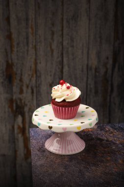 Küçük seramik tabakta kekin altında tahta tabaka ve fotokopi alanı var. Ürün fotoğrafı..