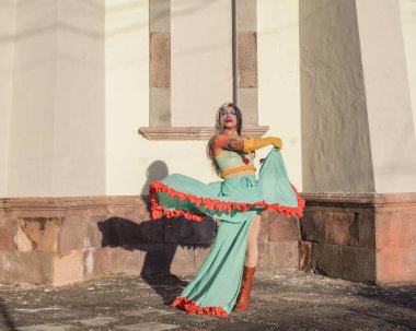 Drag Queen kameraya poz veriyor. Açık havada gündüz resmi.